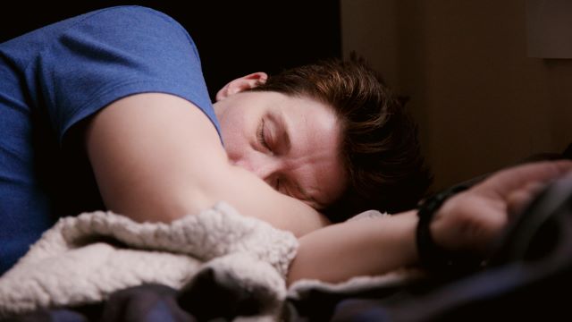 A guy sleeping on bed and sunlight on his face