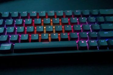 A mechanical keyboard on a desk with glowing RGB