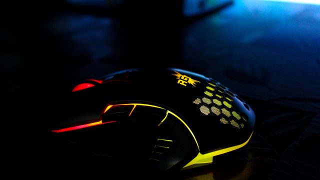 A gaming mouse on a dark desk