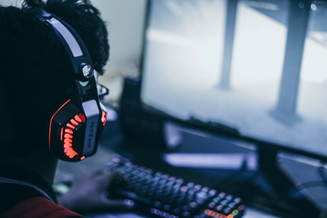 A guy playing game with a RGB gaming headphone